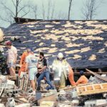 a group of workers search in rubble after a tornado swept through and leveled a church